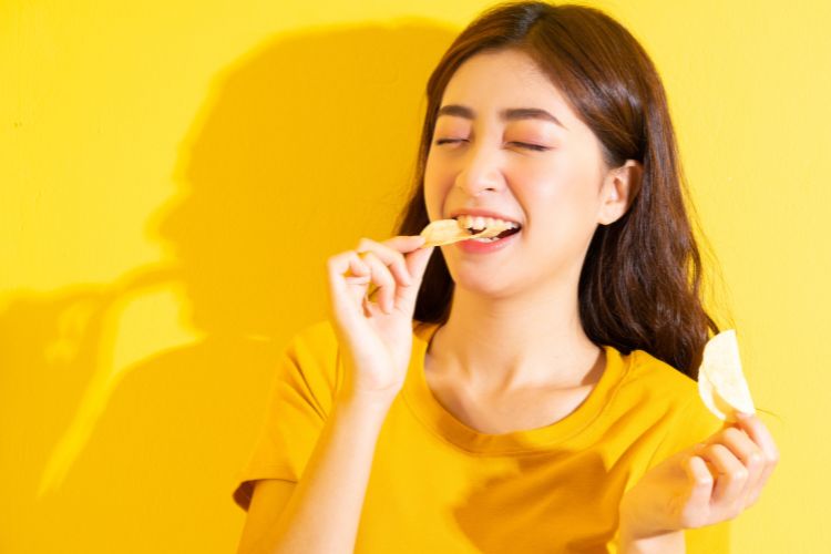 chica joven comiendo snacks