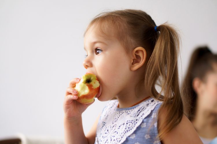 niña comiendo manzana