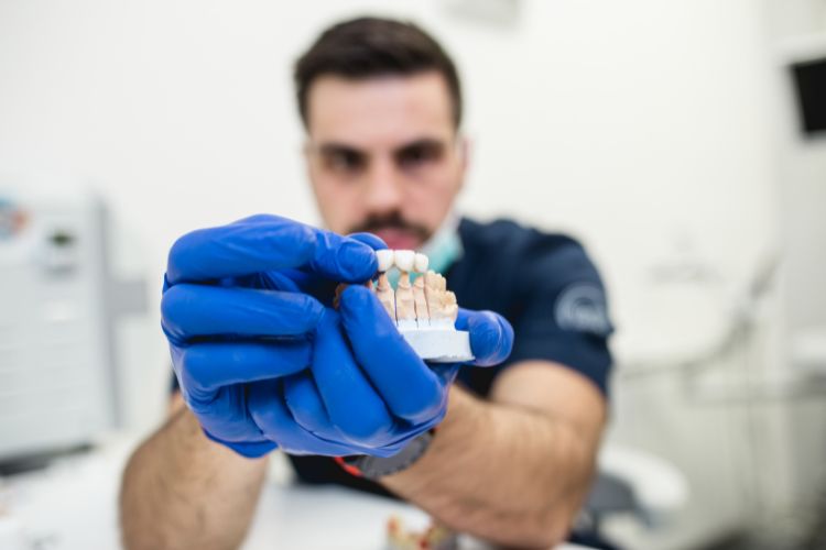 dentista enseñando una protesis dental