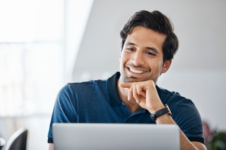 hombre soriendo frente al ordenador